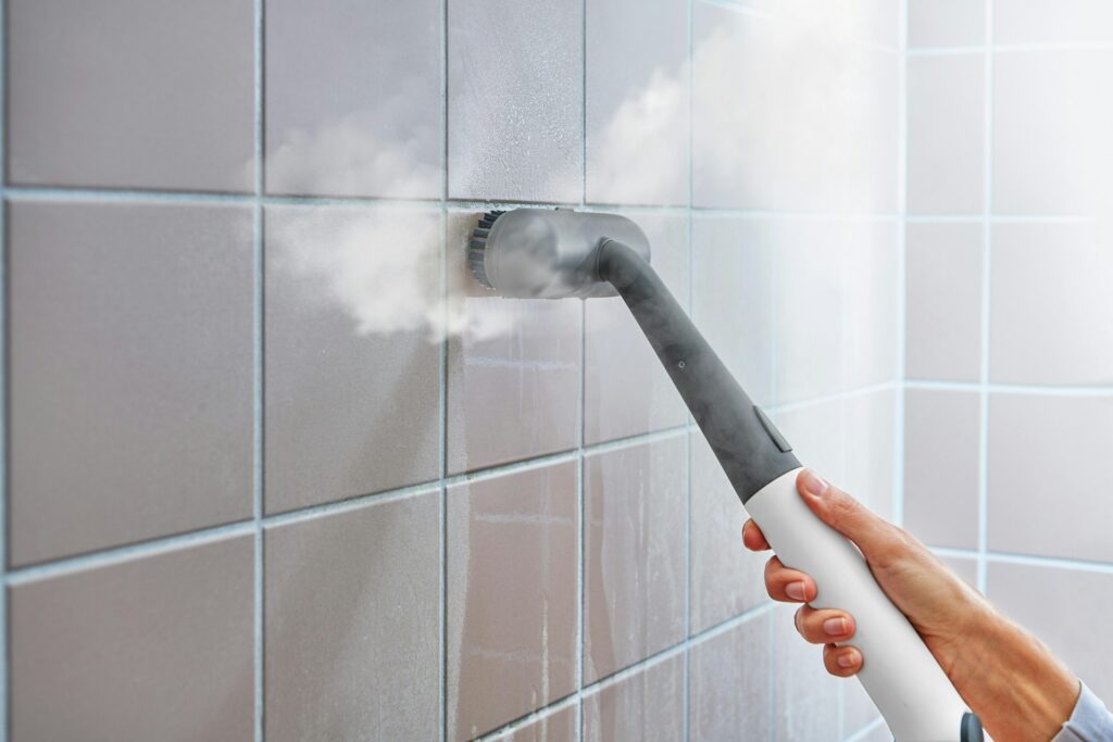 Steam cleaner removing mold from tile grout during mold removal DIY